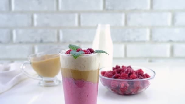 Delicious layered yogurt dessert with applesauce, raspberries and banana. The dessert is decorated with raspberries and mint and served in a glass. Step-by-step instruction. Step 0 — Stock Video