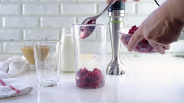 Delicious layered yogurt dessert with applesauce, raspberries and banana. Step-by-step instruction. Step 1. Put frozen raspberries in a glass and pour yogurt — Stock Video