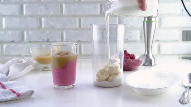 Delicious layered yogurt dessert with applesauce, raspberries and banana. Step-by-step instruction. Step 6. Pour the banana with yogurt and stir with a blender — Stock Video