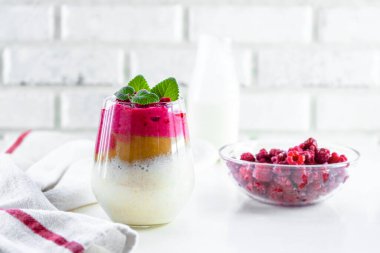 Elma soslu, ahududu ve muzlu lezzetli yoğurt tatlısı. Tatlı ahududu ve nane ile süslenir ve bir bardakta servis edilir. Boşluğu kopyala.