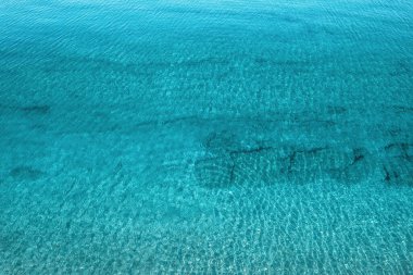 Sakin deniz suyu, taş, levha, yumru ve mercanla havadan kumsal manzarası. Yaz tatili. Mavi okyanus gölü, deniz kıyısı, kıyı şeridi. Drone, helikopter üst görünümü. 