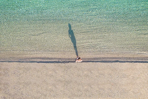 年轻的女运动员戴着帽子 穿着泳衣赤脚在海滨沙滩上行走 从上面看俯瞰 科普特 — 图库照片