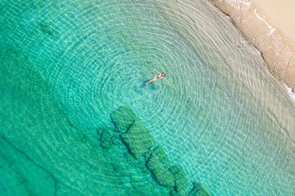 穿着泳衣的年轻女子在海滩上的海水中游泳 从上面看顶部 无人驾驶飞机视图 — 图库照片