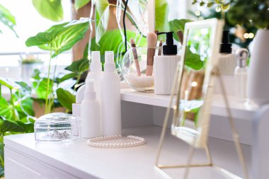 Noel ağacının yansıması, ampuller, makyaj malzemeleriyle makyaj masasındaki kadın aynası.