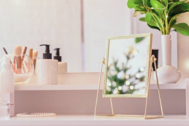 Noel ağacının yansıması, ampuller, makyaj malzemeleriyle makyaj masasındaki kadın aynası.