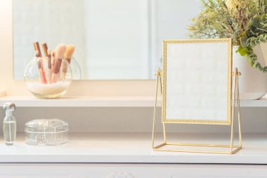 Makyaj aksesuarlarıyla birlikte makyaj masasının üzerindeki masa aynası. Kişisel bakım. Beyaz, pastel iç döşeme