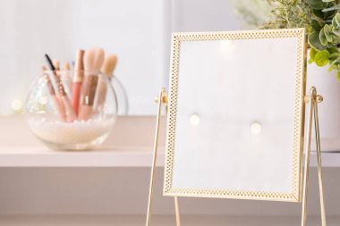 Noel ağacının yansıması, ampuller, makyaj malzemeleriyle makyaj masasındaki kadın aynası.