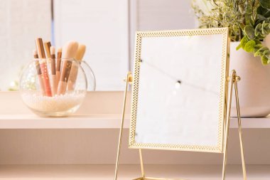 Noel ağacının yansıması, ampuller, makyaj malzemeleriyle makyaj masasındaki kadın aynası.