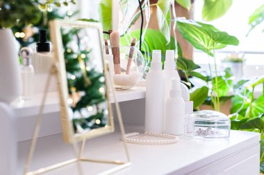 Noel ağacının yansıması, ampuller, makyaj malzemeleriyle makyaj masasındaki kadın aynası.