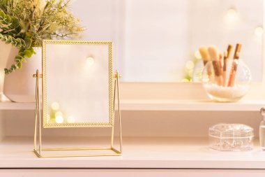 Noel ağacının yansıması, ampuller, makyaj malzemeleriyle makyaj masasındaki kadın aynası.