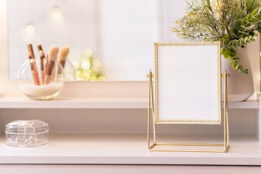 Makyaj aksesuarlarıyla birlikte makyaj masasının üzerindeki masa aynası. Kişisel bakım. Beyaz, pastel iç döşeme. Bulanık geri dönüş