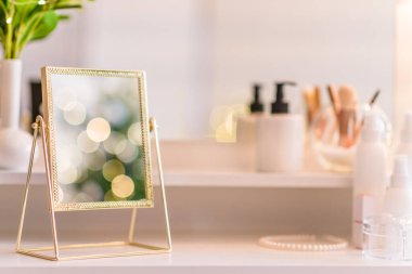 Noel ağacının yansıması, ampuller, makyaj malzemeleriyle makyaj masasındaki kadın aynası.