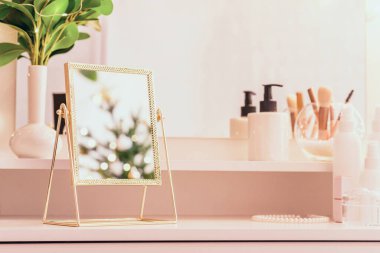 Noel ağacının yansıması, ampuller, makyaj malzemeleriyle makyaj masasındaki kadın aynası.