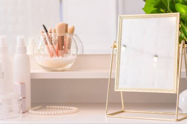 Noel ağacının yansıması, ampuller, makyaj malzemeleriyle makyaj masasındaki kadın aynası.