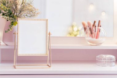Makyaj aksesuarlarıyla birlikte makyaj masasının üzerindeki masa aynası. Kişisel bakım. Beyaz, pastel iç döşeme