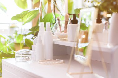 Makyaj aksesuarlarıyla birlikte makyaj masasının üzerindeki masa aynası. Kişisel bakım. Beyaz, pastel iç döşeme