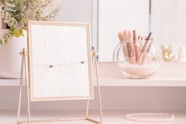 Makyaj aksesuarlarıyla birlikte makyaj masasının üzerindeki masa aynası. Kişisel bakım. Beyaz, pastel iç döşeme
