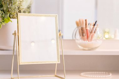 Noel ağacının yansıması, ampuller, makyaj malzemeleriyle makyaj masasındaki kadın aynası.