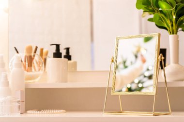 Noel ağacının yansıması, ampuller, makyaj malzemeleriyle makyaj masasındaki kadın aynası.