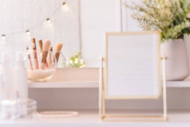 Noel ağacının yansıması, ampuller makyaj aksesuarlarıyla makyaj masasındaki kadın aynasında. Bulanık geri dönüş