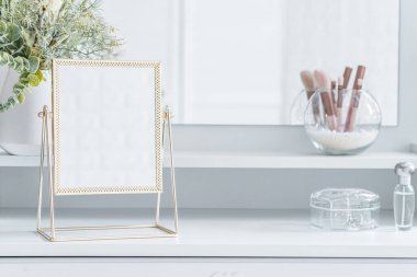 Makyaj aksesuarlarıyla birlikte makyaj masasının üzerindeki masa aynası. Kişisel bakım. Beyaz, pastel iç döşeme