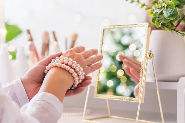 여자들은 팔찌를 액세서리 가까이에 크리스마스 트리의 테이블 거울에 — 스톡 사진