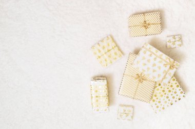 Kar beyazı halıda yatan aile için beyaz altın kağıtlara sarılı Noel hediyeleri kutuları. Uzayı kopyala Üst görünüm 