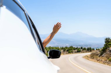 Pencereden elini uzatıp araba kullanan bir kadın. Dağlardaki yılanlı yolda yolculuk. Yaz tatili. Özgürlük kavramı. Boşluğu kopyala