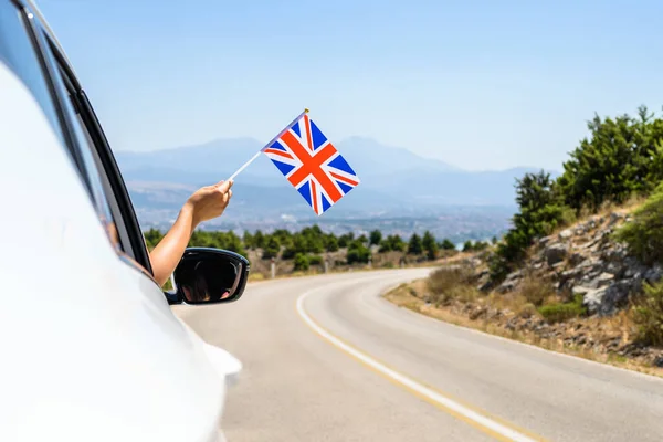 Kvinna Som Håller Förenade Kungarikets Flagga Från Den Öppna Bilrutan — Stockfoto