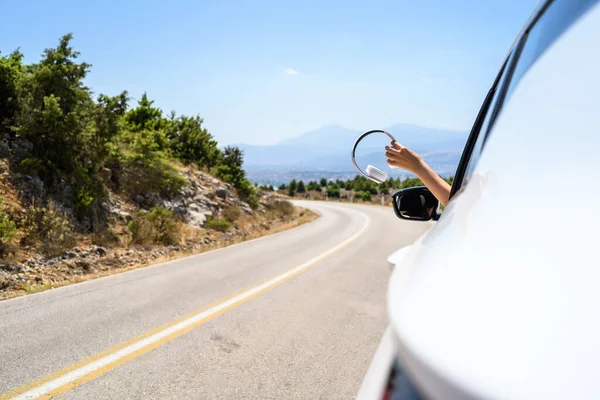 Γυναίκα Οδηγεί Ένα Αυτοκίνητο Κρατώντας Ακουστικά Από Ανοιχτό Παράθυρο Ταξίδι — Φωτογραφία Αρχείου