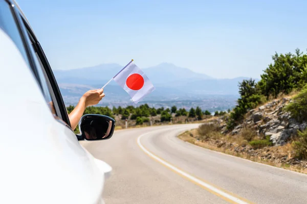 Женщина Держащая Японский Флаг Открытого Окна Машины Едет Змеиной Дороге — стоковое фото
