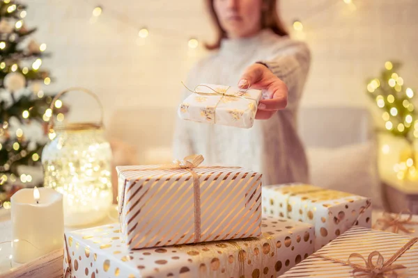 クリスマスツリーの近くのソファに座り 手作りのギフトボックスを梱包してテーブルの上に置きます 家族へのプレゼント — ストック写真