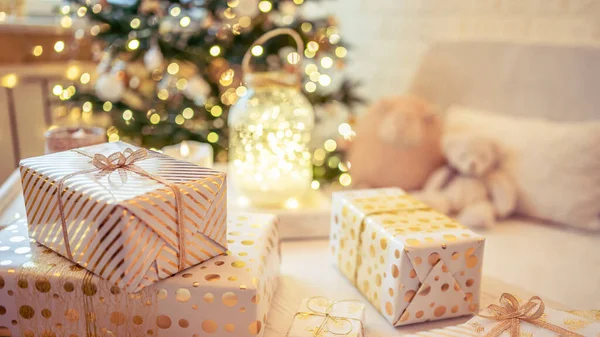 金色のライト 輝くガーランド キャンドルの真ん中にクリスマスツリーの近くのテーブルの上に横たわる手作りのギフトボックスを梱包することがたくさんあります 焦点を合わせて — ストック写真