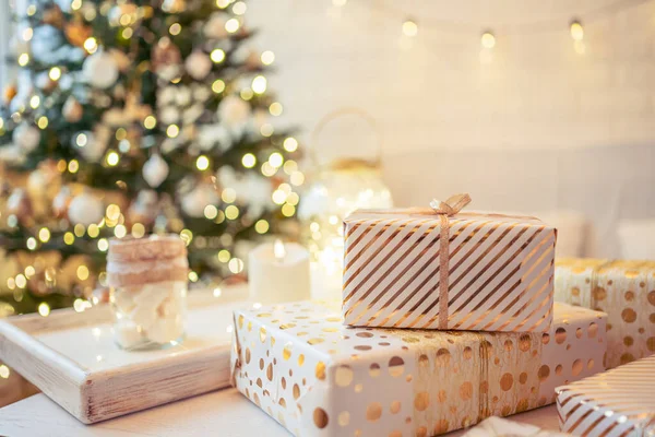 金色のライト 輝くガーランド キャンドルの真ん中にクリスマスツリーの近くのテーブルの上に横たわる手作りのギフトボックスを梱包することがたくさんあります ソフトフォーカス — ストック写真