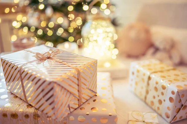 金色のライト 輝くガーランド キャンドルの真ん中にクリスマスツリーの近くのテーブルの上に横たわる手作りのギフトボックスを梱包することがたくさんあります ソフトフォーカス — ストック写真