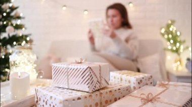 El yapımı hediye kutularını paketledikten sonra koltukta oturan kadın. Aile için hediyeler