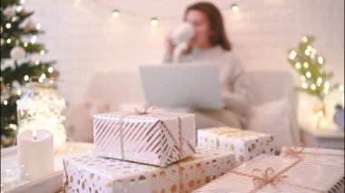 El yapımı hediye kutularını paketledikten sonra koltukta oturan kadın. Aile için hediyeler