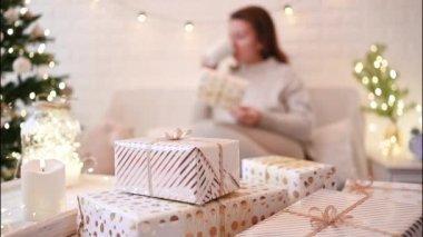 El yapımı hediye kutularını paketledikten sonra koltukta oturan kadın. Aile için hediyeler