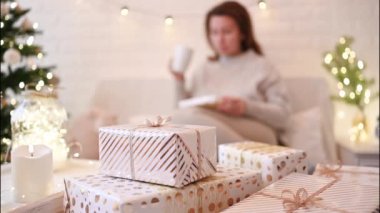 El yapımı hediye kutularını paketledikten sonra koltukta oturan kadın. Aile için hediyeler