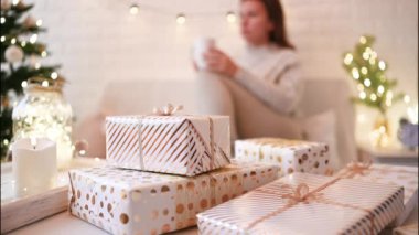 El yapımı hediye kutularını paketledikten sonra koltukta oturan kadın. Aile için hediyeler