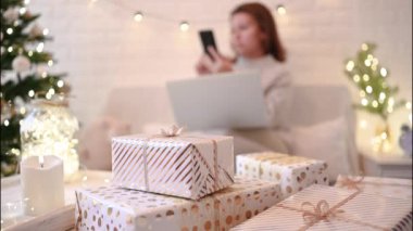 El yapımı hediye kutularını paketledikten sonra koltukta oturan kadın. Aile için hediyeler