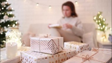 El yapımı hediye kutularını paketledikten sonra koltukta oturan kadın. Aile için hediyeler