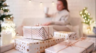 El yapımı hediye kutularını paketledikten sonra koltukta oturan kadın. Aile için hediyeler