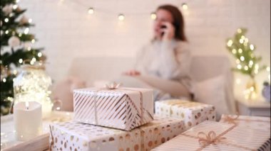 El yapımı hediye kutularını paketledikten sonra koltukta oturan kadın. Aile için hediyeler
