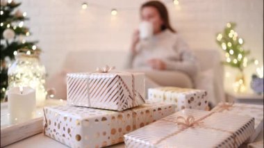 El yapımı hediye kutularını paketledikten sonra koltukta oturan kadın. Aile için hediyeler