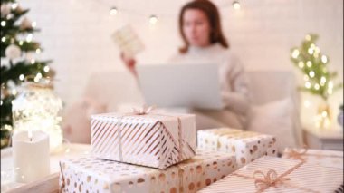El yapımı hediye kutularını paketledikten sonra koltukta oturan kadın. Aile için hediyeler