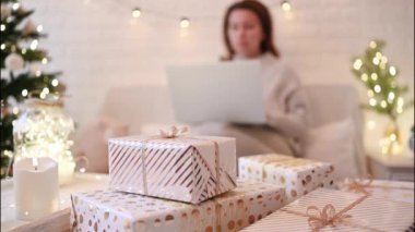 El yapımı hediye kutularını paketledikten sonra koltukta oturan kadın. Aile için hediyeler