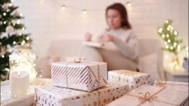 El yapımı hediye kutularını paketledikten sonra koltukta oturan kadın. Aile için hediyeler