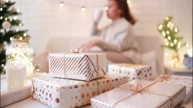 El yapımı hediye kutularını paketledikten sonra koltukta oturan kadın. Aile için hediyeler