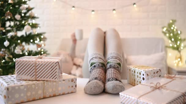 Vrouw Bank Bij Kerstboom Vrouwelijke Benen Voeten Winter Wollen Sokken — Stockvideo